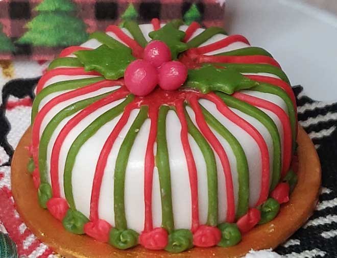 ho ho ho miniature santa and a beautiful striped christmas cake scene